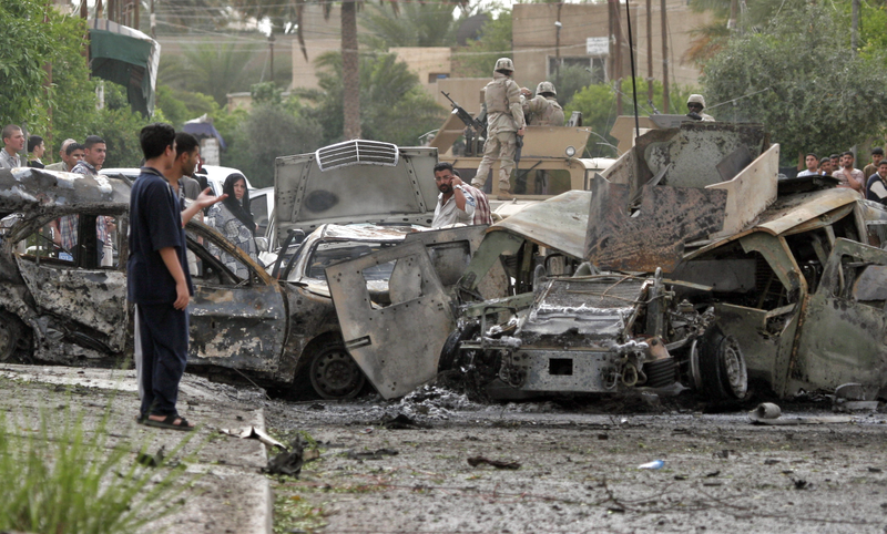 Iraqis and US Army soldiers arrive to the scene after a US Army convoy was attacked by a car bomb in the western part of Baghdad, Iraq, Sunday, May 1, 2005.